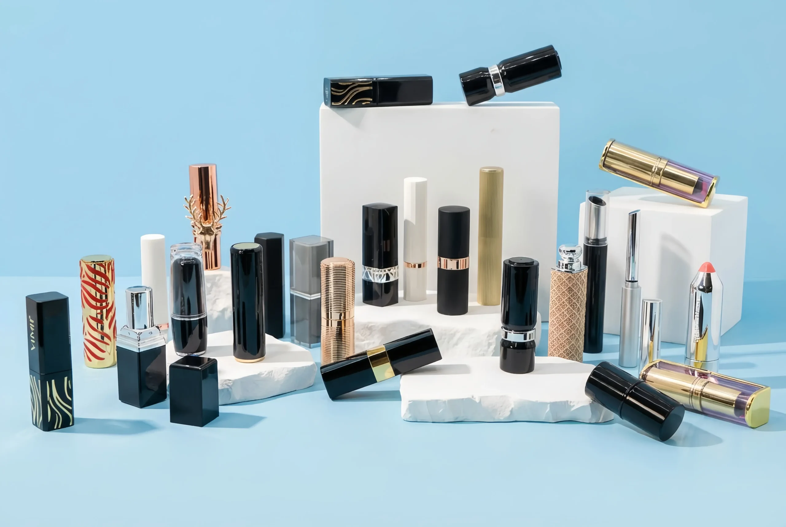 Variety of empty lipstick tubes displayed including black square cases, gold textured cylinders, and slim styles, manufactured by China factory.